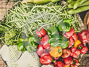 Close-up heap of pile raw red green yellow bell-pepper, green beans and broccoli on a local asia farmers market. Cooking