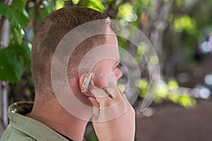 Close-up of a hearing aid on a man's ear.