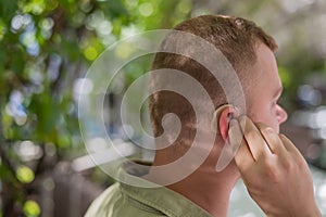 Close-up of a hearing aid on a man's ear.