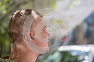 Close-up of a hearing aid on a man's ear.