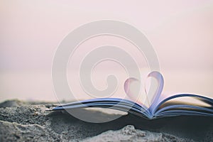 Close up heart book on sand in the beach with vintage filter blur background