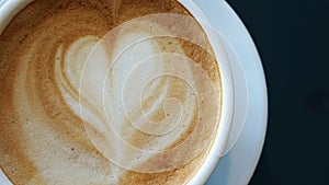 Close up of heart froth, Love foam of latte hot coffee in a white cup, Top view.