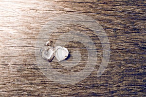 Close up of heart locket on wooden background with retro style