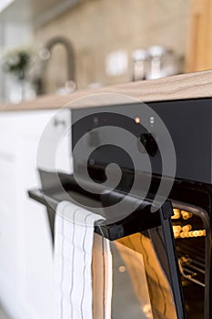 Closeup on heating up electric oven with ajar door at kitchen