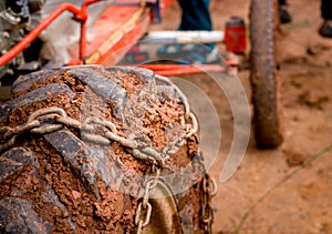 Close up heavy muck truck wheel off road car tire with chain o