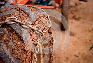 Close up heavy muck truck wheel off road car tire with chain o