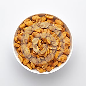 Close up of Heeng jeera Peanuts mixture Indian namkeen snacks on a ceramic white bowl.