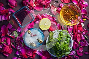 Close up of a herbal face pack consisting of Aloe Vera gel,honey,milk cream,lemon and rose with rose water and rose petals on wood