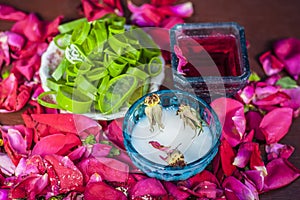 Close up of a herbal face pack consisting of Aloe Vera gel,honey,milk cream,lemon and rose with rose water and rose petals on wood