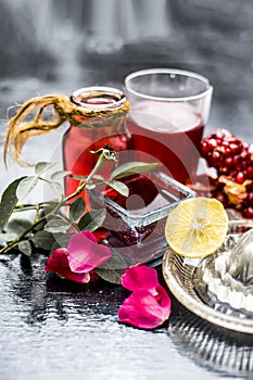 Close up of herbal face pack of pomegranate and lemon juice with rose water on wooden surface with some sliced lemons and pomegran