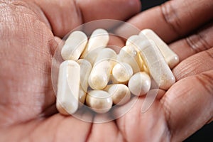 close up of herbal medicine capsule on hand