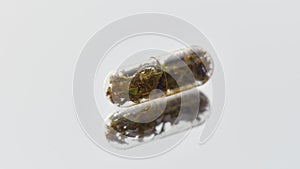 Close up of herbal pill, capsule, drug isolated over light background. Alternative medicine, treatment concept