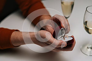 Close-up high-angle view of loving young man making proposal for marriage to woman at table with candles, marry me.