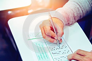 Close up , High School male student holding pencil exams writing in classroom for education test ,Copy space for your text.