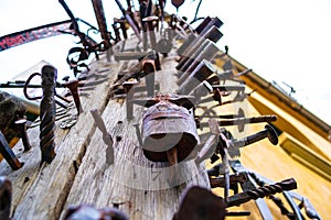 Close up of a high wooden pole Journeymen Pillar with iron/steel nails bolted in it, as a symbol of craftsmanship.