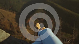 Close up hiking boots of Independent Woman traveller on top of mountain looking at view. Hiker girl dangling feet over