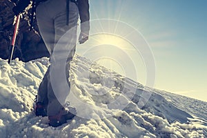 Close up of hiking shoes with crampons and ice axe.