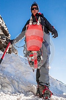 Close up of hiking shoes with crampons and ice axe.