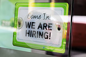 Close-up Of A `We Are Hiring` Sign On Glass Door