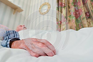 Elderly infirm man lying asleep in bed after being discharged from hospital photo