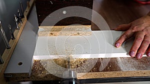 Close-up of a hole in a wood panel using a drill press. A drilling machine makes a hole in an MDF panel. About to