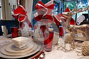 Close up of holiday Christmas table setting in white, silver, and red