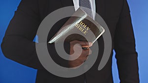 Close up, holy bible in the hands of black african american man in elegant suit