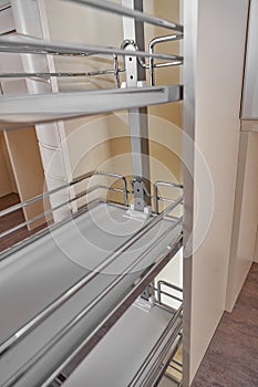 Close Up home interior. Kitchen - opened door with chrome furniture shelf. Wood and Chrome Material, Modern Design