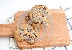 Close up of home made chocolate chip cookies on a wooden plate