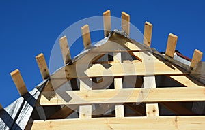 Close up on home wooden roofing construction. Installing wooden rafters, logs, eaves, timber