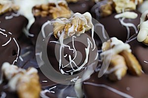 Close up of homemade black and white christmas chocolate pralines filled with walnuts, marzipan and figs