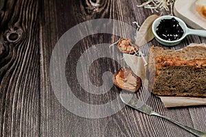 Close up Homemade delicious freshly baked classic sweet banana bread sliced with blueberry/strawberry jam and butter knife on a wo