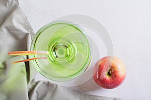close up of homemade green apple martini cocktail with apple pieces in glasses top view