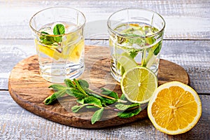 Close-up of homemade lemonade with lemon, lime and mint on wooden Board