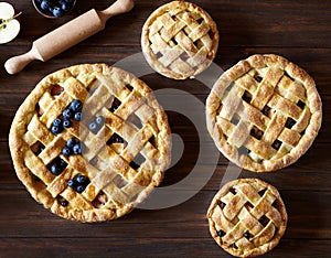 Close up. Homemade pastry apple pie pies bakery on dark wooden kitchen table with raisins, blueberry and apples