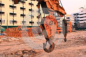 Close up hook and crane in working site,project building hospital construction for health services in urban with cranes and worker