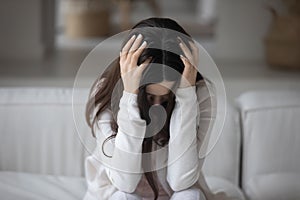 Close up hopeless unhappy young woman holding head, feeling depressed