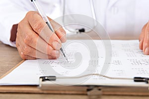 Close-up of hospital doctor checking the list with pen