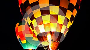 Close up of hot air balloon with burner flame glowing at night