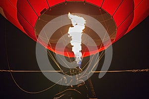 Close-up of a hot air balloon inflated with fire glowing at night during an airshow festival