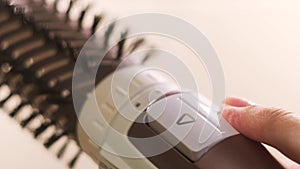 Close up of hot air rotating hair styler in female hands. Concept. Woman hands showing the work of air dryer isolated on