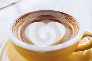 Close up hot cappuccino coffee cup on wooden tray with heart latte art on wood table at cafe,Banner size food and drink concept