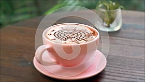 Close-up of Hot Ceramic Pink Coffee Cup on Saucer with Chocolate Latte Art