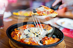 Close-up of hot fresh pizza lifted slice