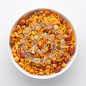 Close-Up of Hot spicy Nav Ratan snacks in a white Ceramic bowl, made with red chili, peanuts. Indian spicy snacks Namkeen, photo