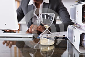 Close-up Of Hourglass On Desk