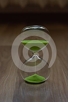 Close-up, hourglass on a wooden table, blurred background