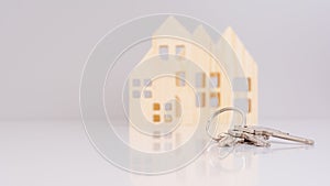 close-up house keys against the background of wooden house models