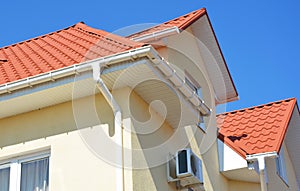 Close up on house metal rooftop with plastic rain gutter pipeline, soffit and fascia boards. Guttering attic house in problem
