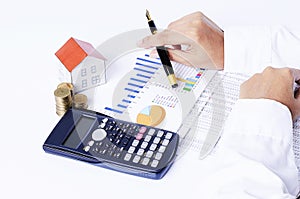 Close up of House paper with coins stack with calculator and han